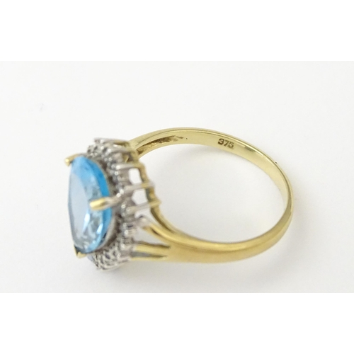 562 - A 9ct gold cocktail ring set with central topaz and diamond. Ring size approx. P