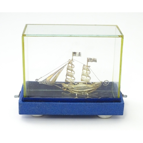 233 - A silver model of a twin masted ship / boat with filigree detail. Marked .925 . The case approx. 4