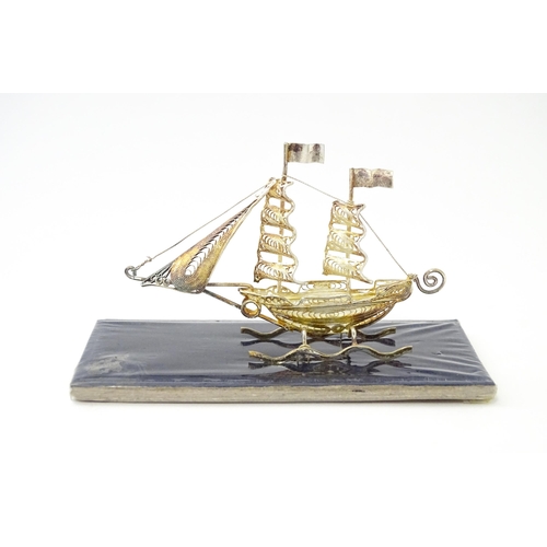 233 - A silver model of a twin masted ship / boat with filigree detail. Marked .925 . The case approx. 4