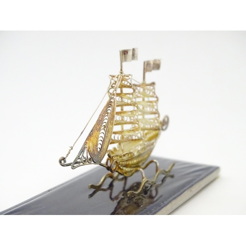 233 - A silver model of a twin masted ship / boat with filigree detail. Marked .925 . The case approx. 4