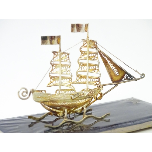 233 - A silver model of a twin masted ship / boat with filigree detail. Marked .925 . The case approx. 4