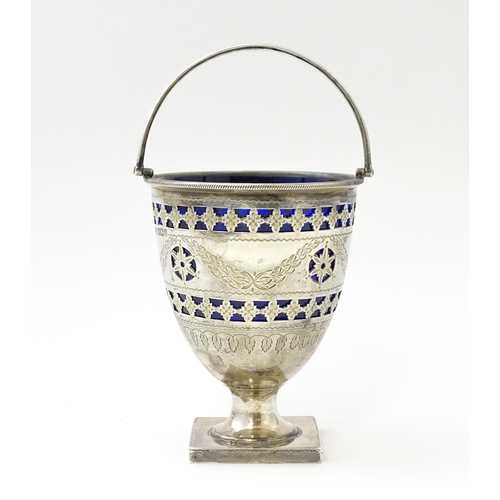 242 - A Victorian silver sugar bowl with swing handle, engraved bright cut decoration and blue glass liner... 