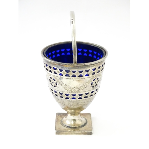 242 - A Victorian silver sugar bowl with swing handle, engraved bright cut decoration and blue glass liner... 