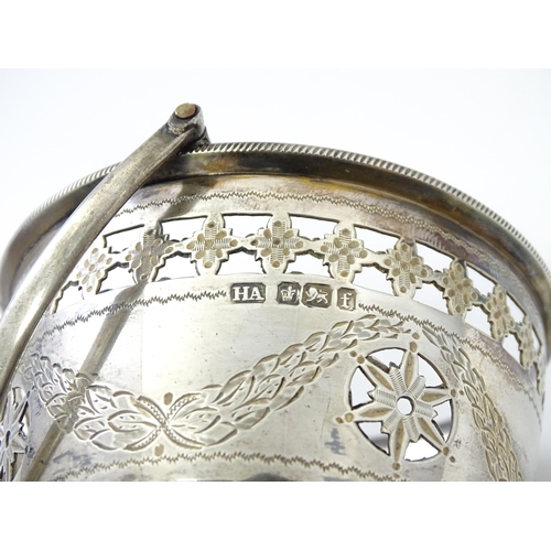 242 - A Victorian silver sugar bowl with swing handle, engraved bright cut decoration and blue glass liner... 