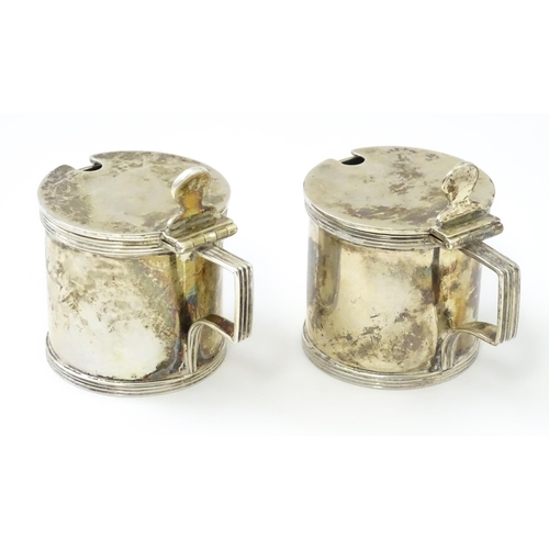 252 - A matched pair of silver mustard pots, one hallmarked London 1930, maker Goldsmiths & Silversmiths C... 