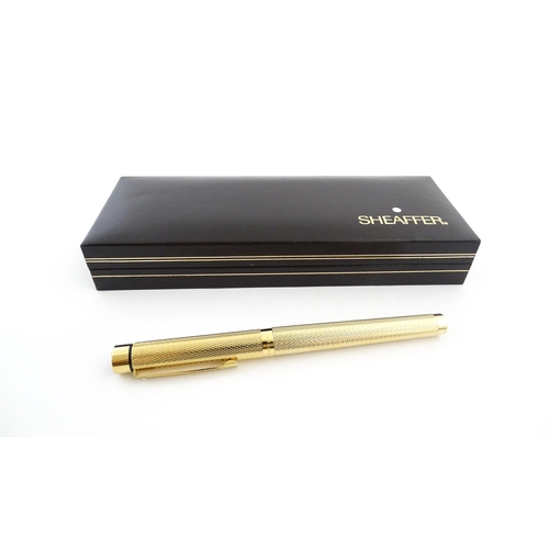 1272 - A cased Sheaffer 'Targa 1009' fountain pen with gold plated chequered barrel and cap, 14ct gold nib,... 