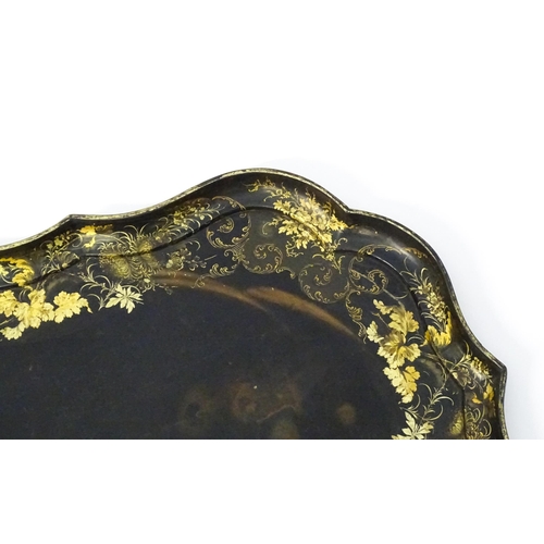 1325 - A Victorian papier-mache tray with a moulded edge and gilt painted floral decoration. Stamped B. Wal... 