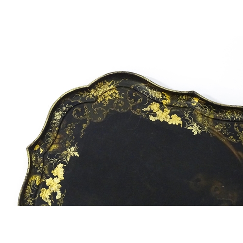 1325 - A Victorian papier-mache tray with a moulded edge and gilt painted floral decoration. Stamped B. Wal... 