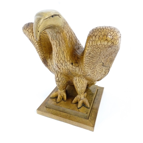 1338 - A 20thC carved wooden model of an eagle with incised feathers and features, by Henry George Pentus B... 