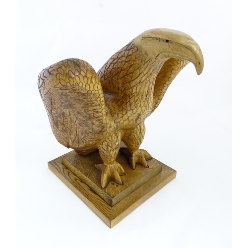 1338 - A 20thC carved wooden model of an eagle with incised feathers and features, by Henry George Pentus B... 