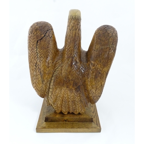 1338 - A 20thC carved wooden model of an eagle with incised feathers and features, by Henry George Pentus B... 