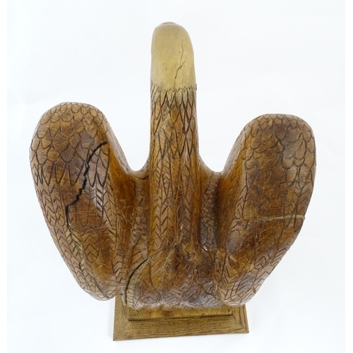 1338 - A 20thC carved wooden model of an eagle with incised feathers and features, by Henry George Pentus B... 