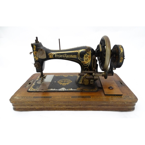 1354 - An early 20thC Frister & Rossmann hand crank sewing machine with floral and foliate decoration. The ... 