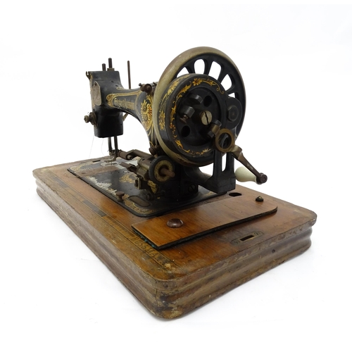 1354 - An early 20thC Frister & Rossmann hand crank sewing machine with floral and foliate decoration. The ... 