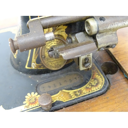 1354 - An early 20thC Frister & Rossmann hand crank sewing machine with floral and foliate decoration. The ... 