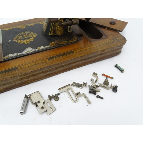 1354 - An early 20thC Frister & Rossmann hand crank sewing machine with floral and foliate decoration. The ... 