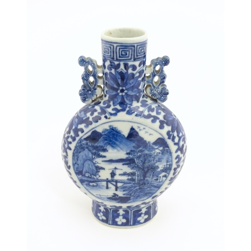 1 - A Chinese blue and white moon flask vase with twin foliate handles, decorated with central vignettes... 