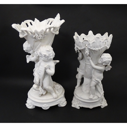 108 - Two bisque vases of cornucopia form with cherub / putti and swag detail. Largest approx. 10