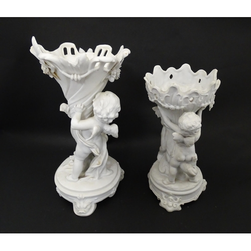 108 - Two bisque vases of cornucopia form with cherub / putti and swag detail. Largest approx. 10