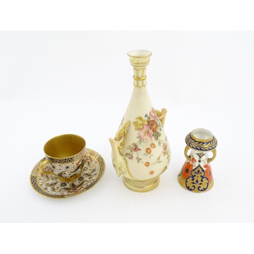 128 - A Royal Worcester blush ivory vase with twin handles of shaped form decorated with flowers and folia... 