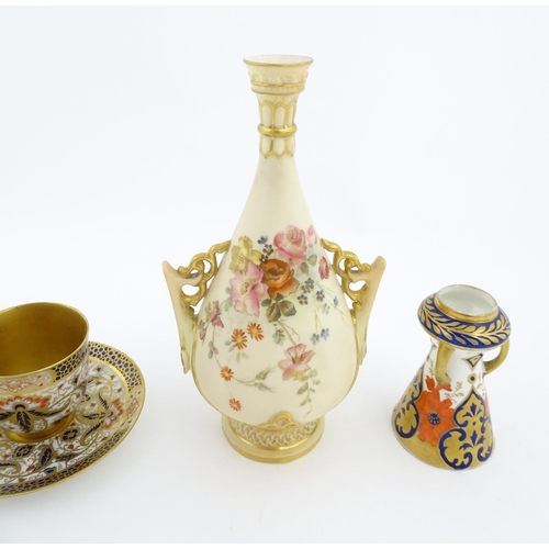 128 - A Royal Worcester blush ivory vase with twin handles of shaped form decorated with flowers and folia... 