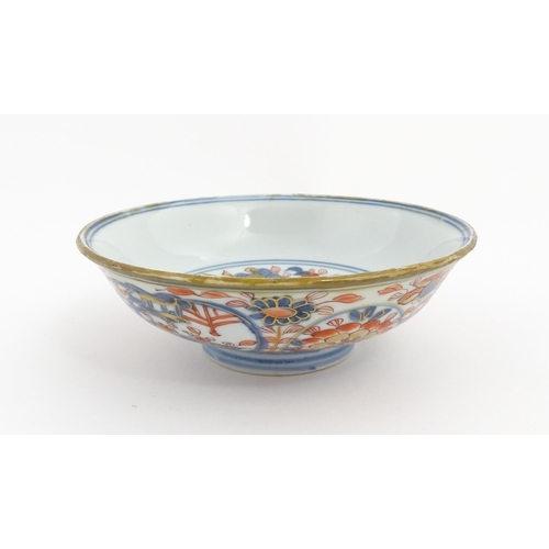 14 - A small Oriental dish decorated in the Imari palette, the centre with stylised fruit tree, the rever... 