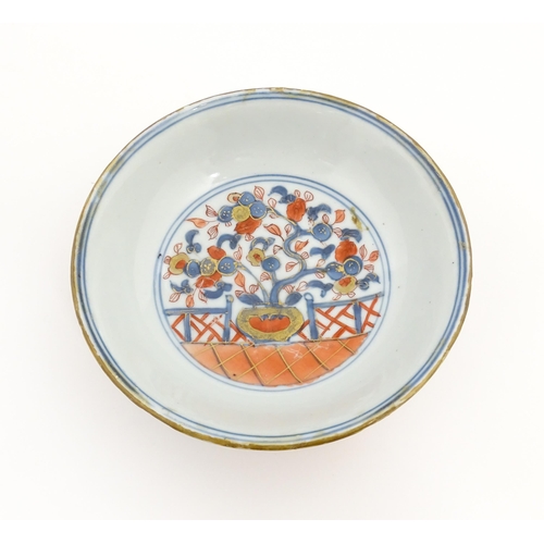 14 - A small Oriental dish decorated in the Imari palette, the centre with stylised fruit tree, the rever... 