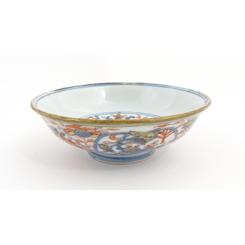 14 - A small Oriental dish decorated in the Imari palette, the centre with stylised fruit tree, the rever... 