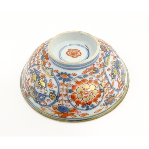 14 - A small Oriental dish decorated in the Imari palette, the centre with stylised fruit tree, the rever... 