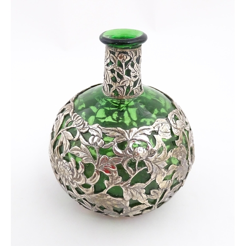 169 - A green glass perfume / scent bottle with white metal floral and foliate overlay in the Oriental sty... 