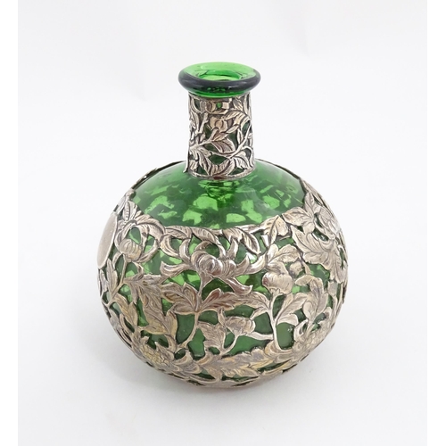 169 - A green glass perfume / scent bottle with white metal floral and foliate overlay in the Oriental sty... 