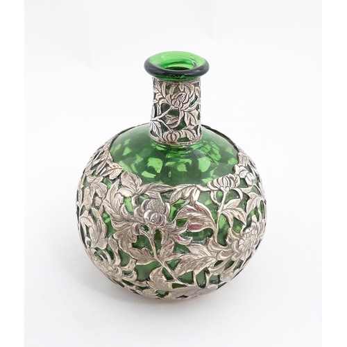 169 - A green glass perfume / scent bottle with white metal floral and foliate overlay in the Oriental sty... 