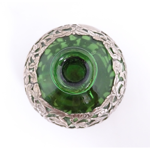 169 - A green glass perfume / scent bottle with white metal floral and foliate overlay in the Oriental sty... 