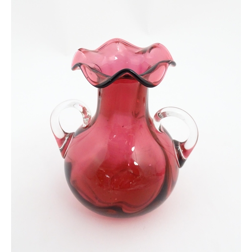 172 - A cranberry glass vase with frilled rim and twin clear glass handles. Approx. 5