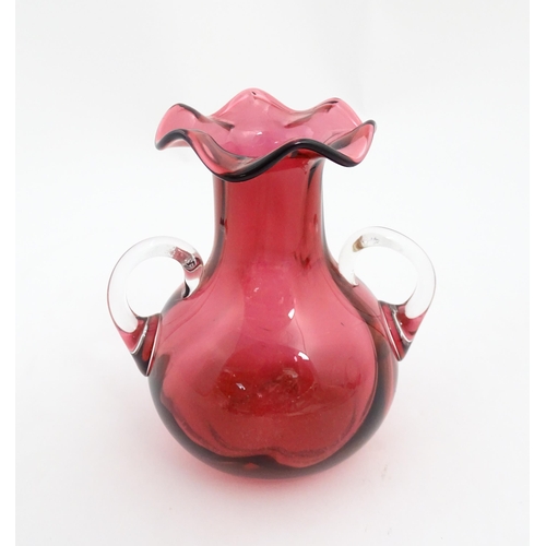 172 - A cranberry glass vase with frilled rim and twin clear glass handles. Approx. 5