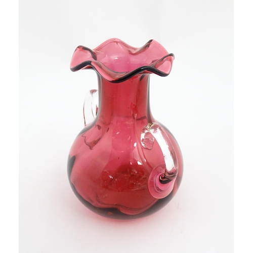 172 - A cranberry glass vase with frilled rim and twin clear glass handles. Approx. 5