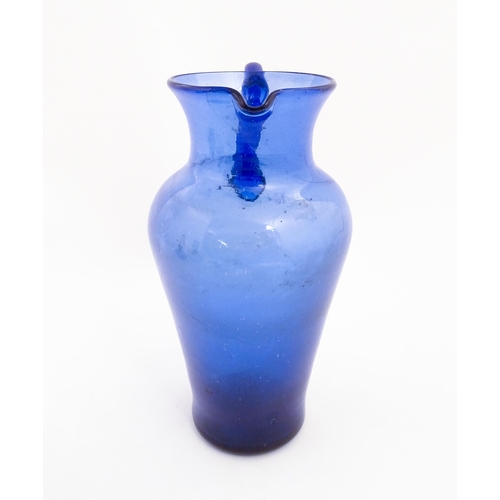 179 - A blue glass jug with loop handle. Approx. 11