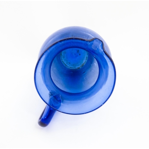 179 - A blue glass jug with loop handle. Approx. 11