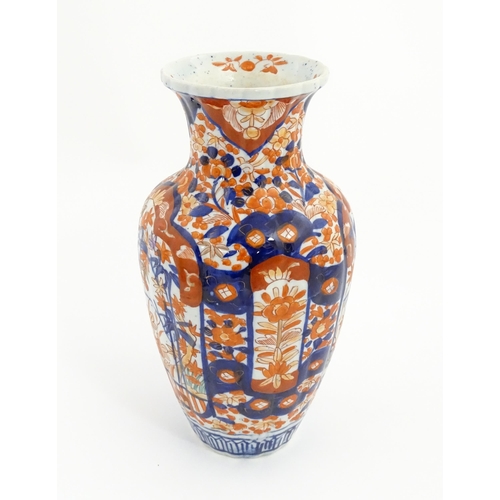 44 - A Japanese vase decorated in the Imari palette with flowers and foliage, with further floral motifs ... 