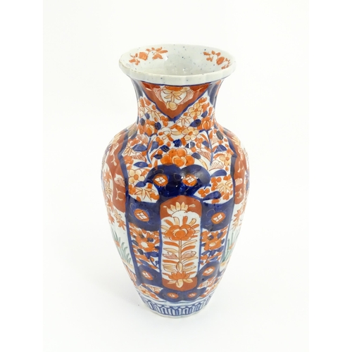 44 - A Japanese vase decorated in the Imari palette with flowers and foliage, with further floral motifs ... 