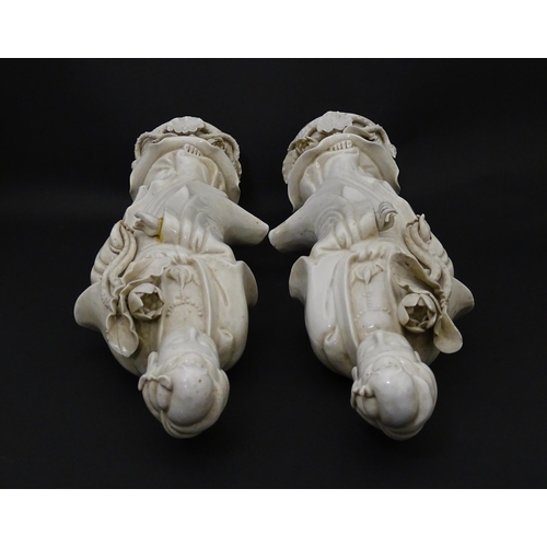 5 - Two Chinese blanc de chine figures modelled as Guanyin holding a flower on a lotus base. Approx. 14