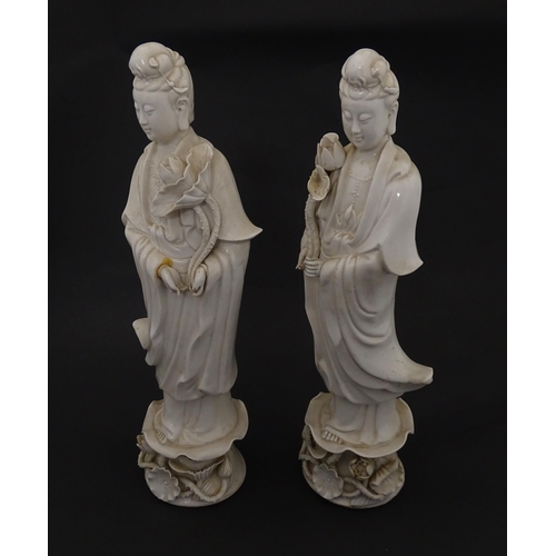 5 - Two Chinese blanc de chine figures modelled as Guanyin holding a flower on a lotus base. Approx. 14