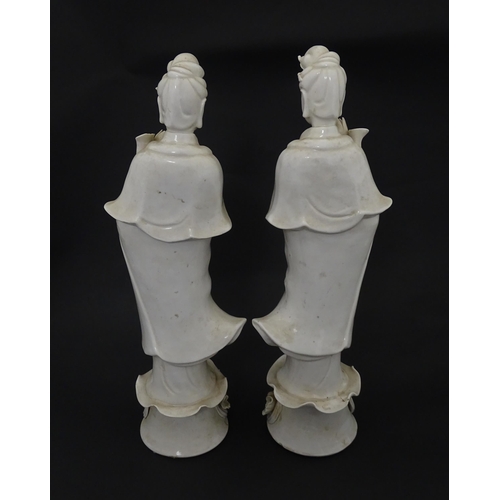 5 - Two Chinese blanc de chine figures modelled as Guanyin holding a flower on a lotus base. Approx. 14