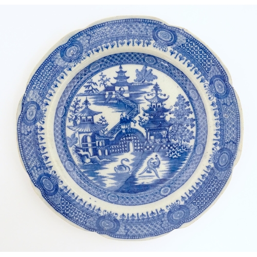 60 - An unusual 19thC blue and white plate decorated with a landscape with pagoda style buildings, a swan... 