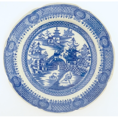 60 - An unusual 19thC blue and white plate decorated with a landscape with pagoda style buildings, a swan... 