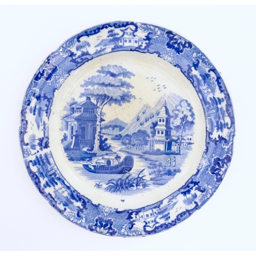 62 - An unusual 19thC blue and white plate decorated with an Oriental river landscape with ornate pagodas... 