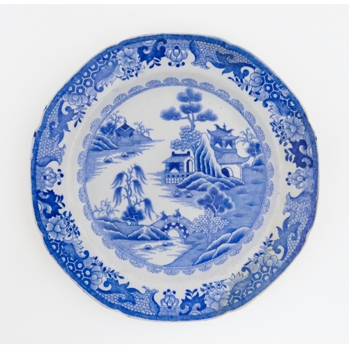 67 - A 19thC Masons blue and white plate decorated in a variation of the Willow pattern. Approx. 9