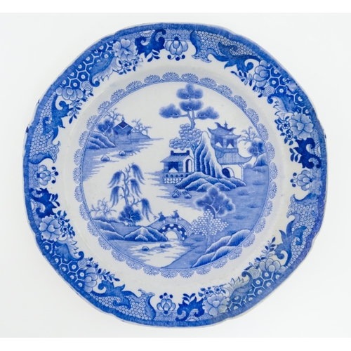 67 - A 19thC Masons blue and white plate decorated in a variation of the Willow pattern. Approx. 9