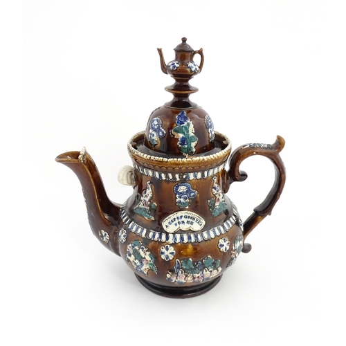 75 - A large Victorian Measham bargeware teapot with miniature teapot finial, decorated with applied flor... 