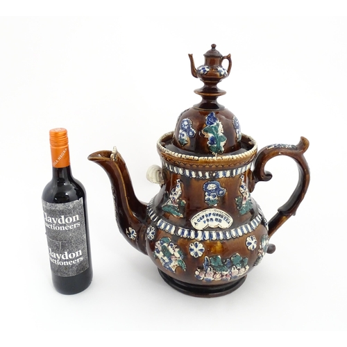 75 - A large Victorian Measham bargeware teapot with miniature teapot finial, decorated with applied flor... 